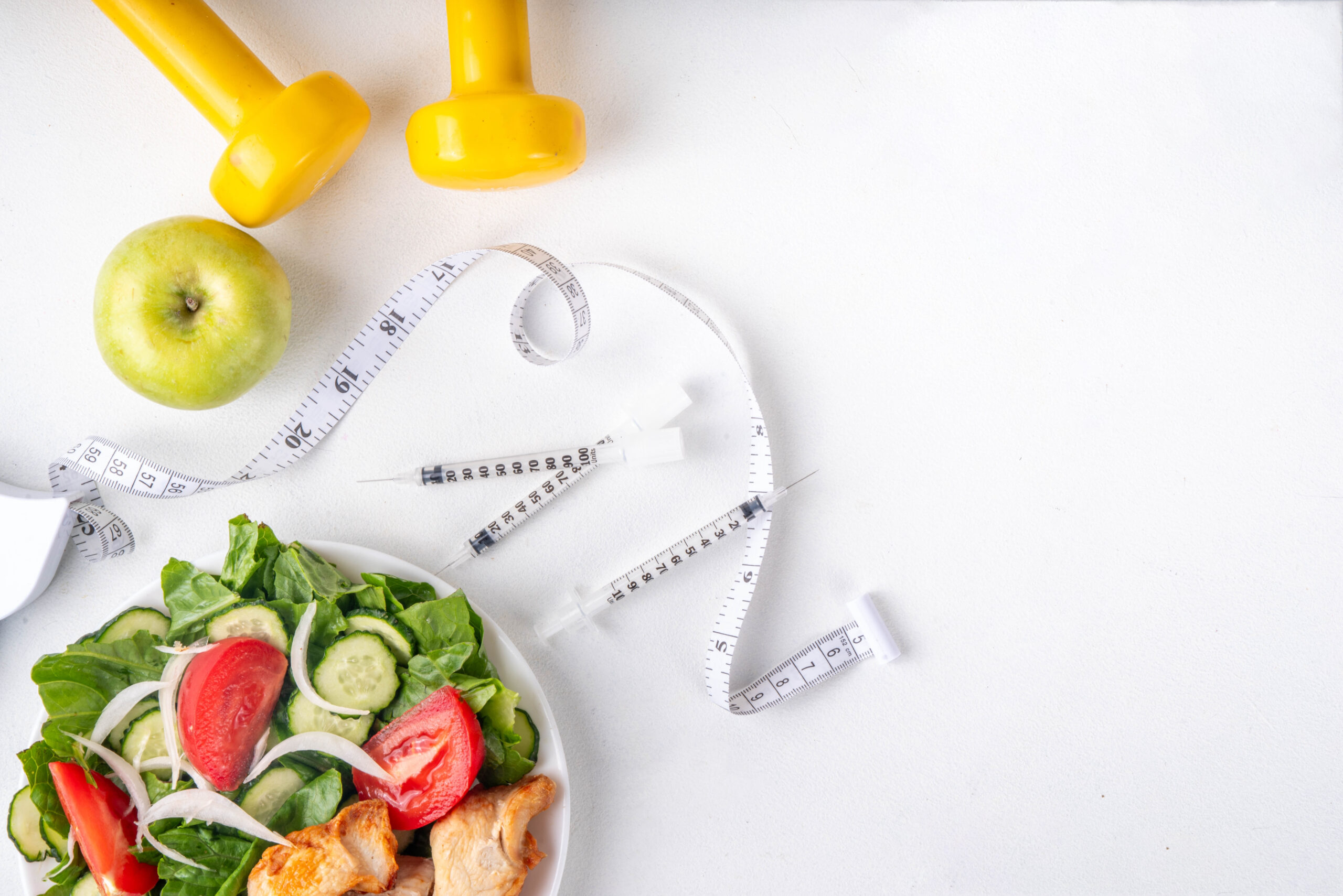 Measuring tape with healthy veggies and syringes