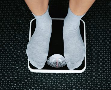 Person Standing On Scale To Measure Weight Loss