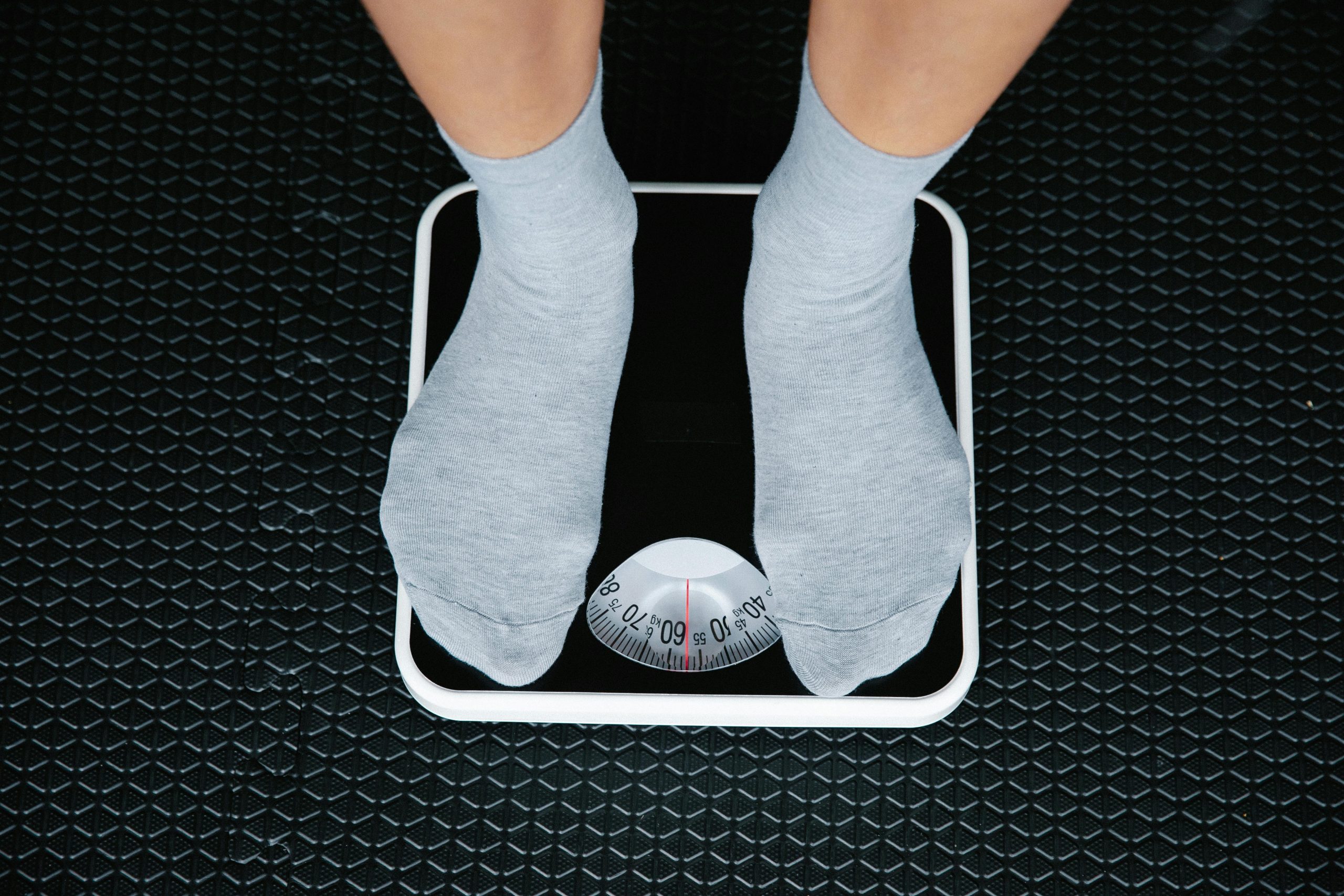 Person standing on scale to measure weight loss