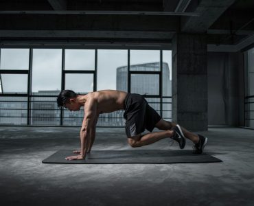 Man Working Out In An Empty Room On A Mat