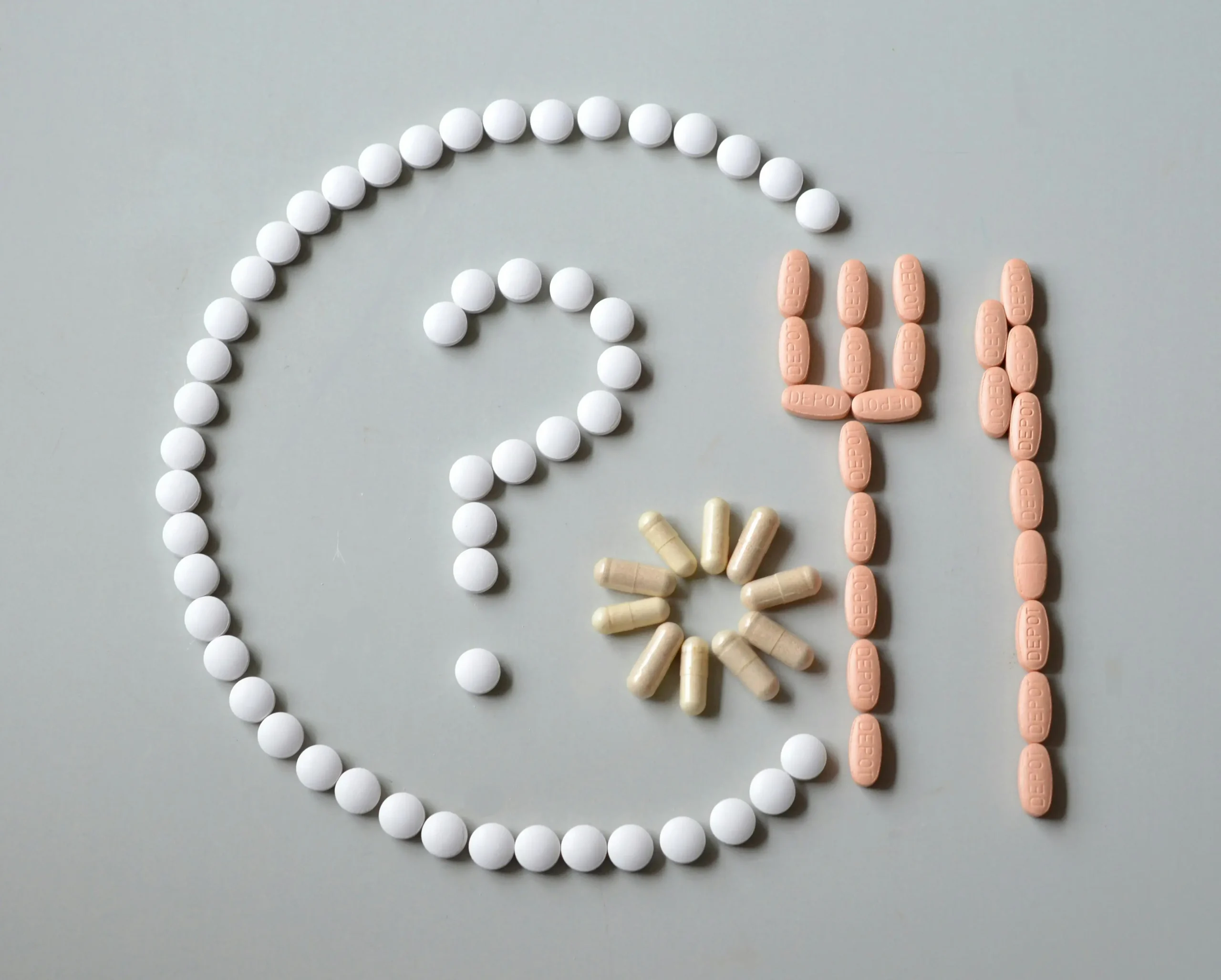 A plate and cutlery made out of pills with a question mark inside